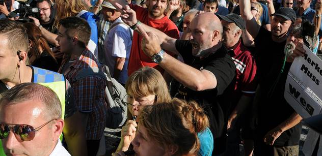 FOTO, ze kterého jde strach: Lidé před Hradem dali najevo, co cítí k Merkelové. A pak se servali o vlajku