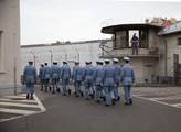 Příslušníci Hradní stráže pochodují areálem věznic...